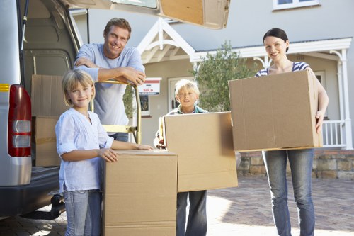 Moving team carrying boxes near a North London flat staircase